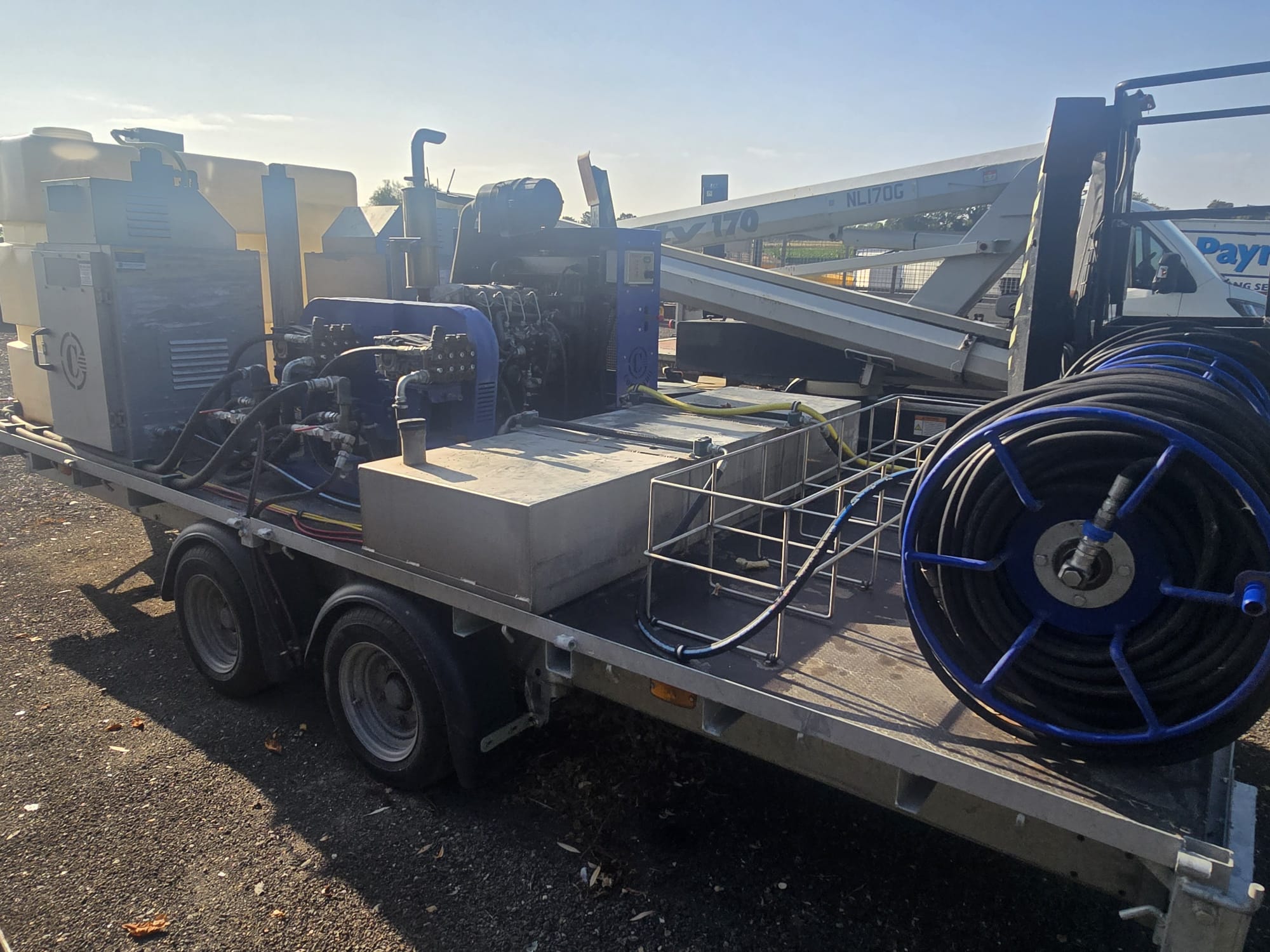 Trailer-mounted wash units, pumps and hose reels with a boom lift behind