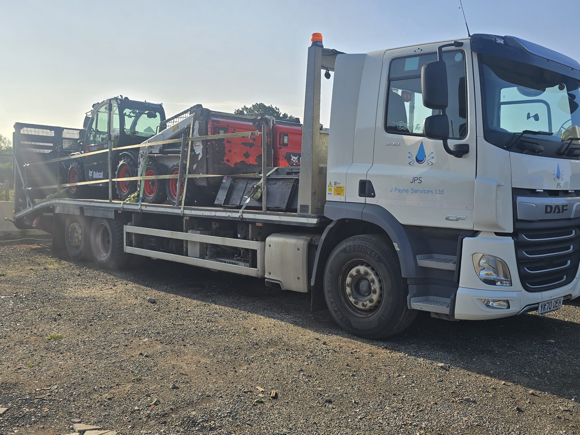 J Payne Services DAF CF flatbed lorry loaded with a Bobcat telehandler and skid steer