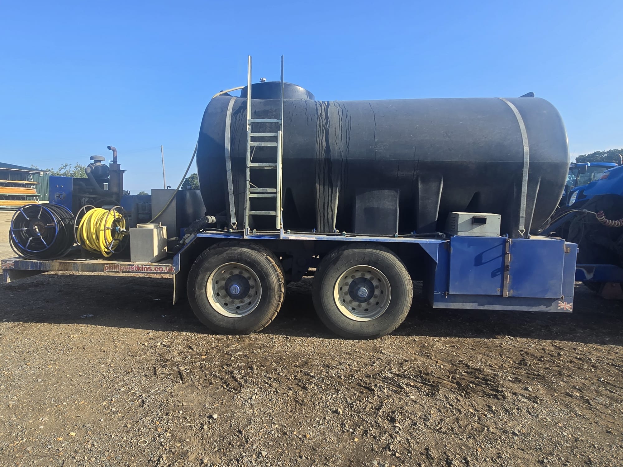 Water bowser trailer with hose reels behind a tractor