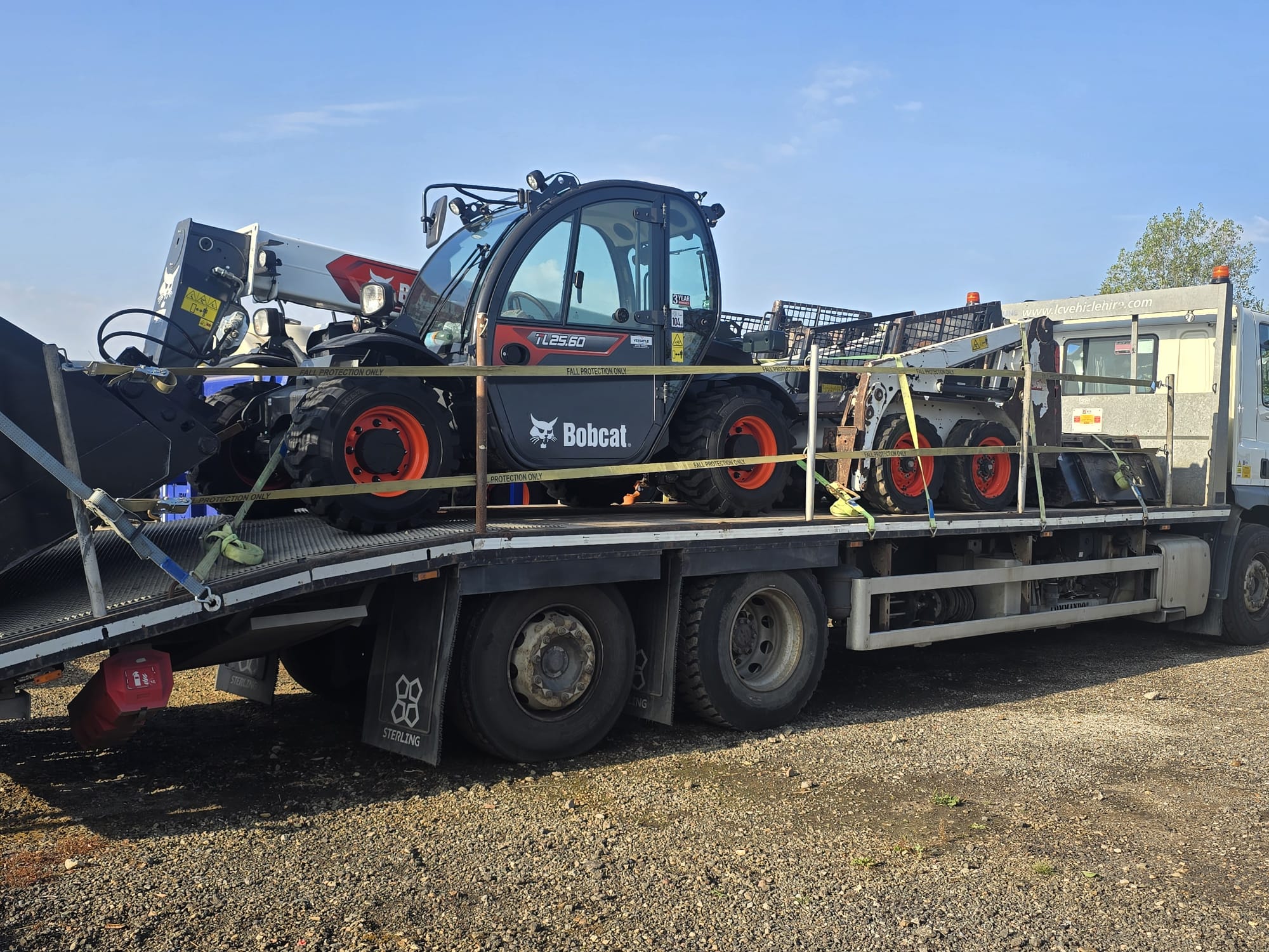 Bobcat TL25.60 telehandler and skid steer strapped down on the flatbed