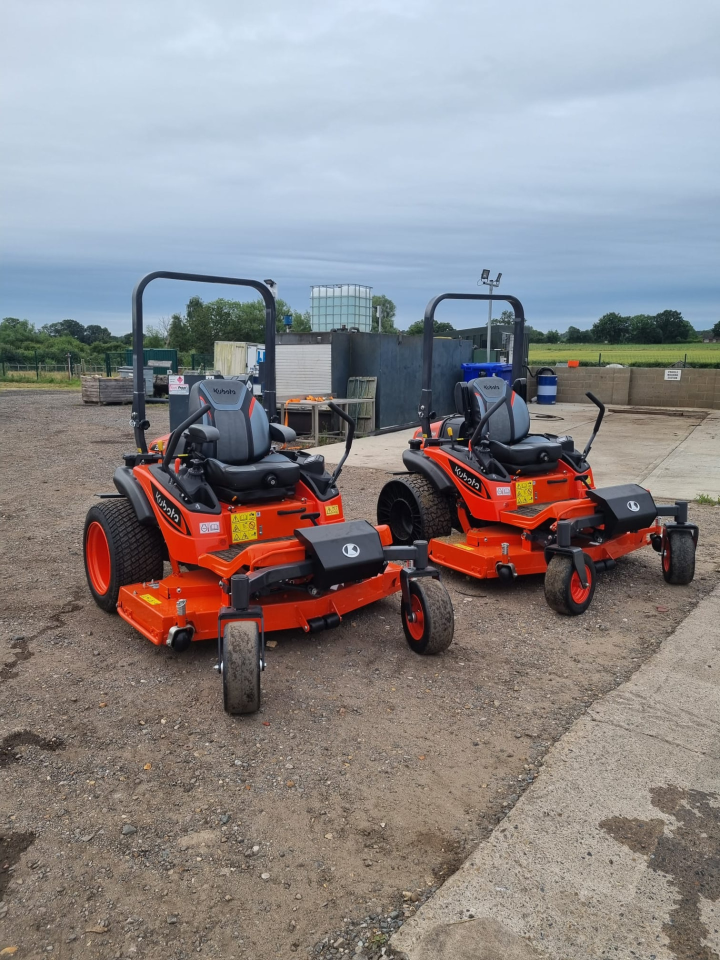 Two Kubota zero-turn mowers parked in the yard