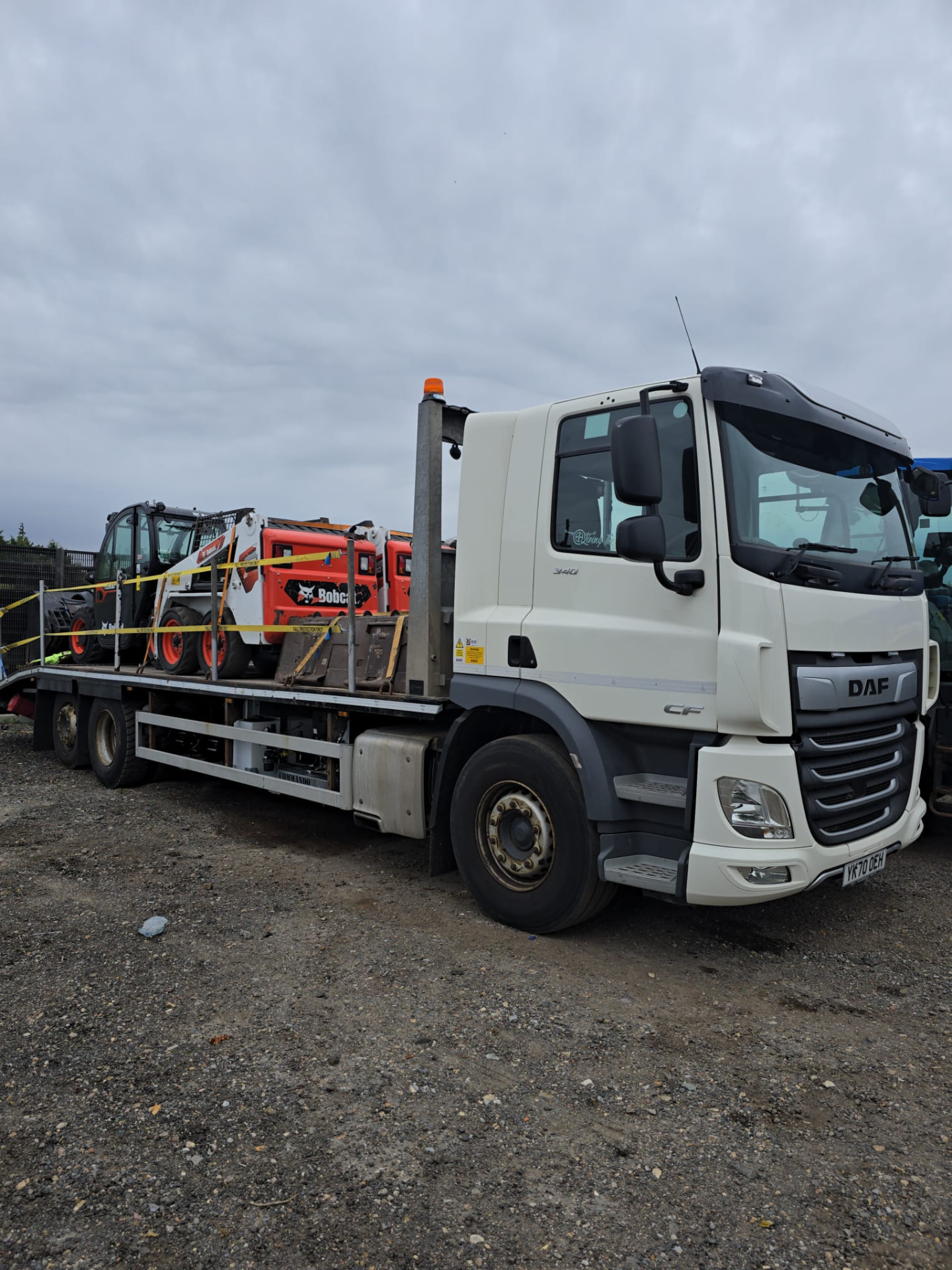DAF flatbed lorry loaded with Bobcat skid steer loaders